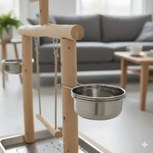 Close-up of two polished stainless steel feeding bowls attached to a parrot play stand.