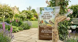 A 12.75kg bag of premium no mess wild bird seed mix being poured into a feeder with a clear scoop in a British garden setting.