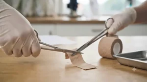 Medical scissors cutting a piece of cohesive bandage tailored for avian first aid.
